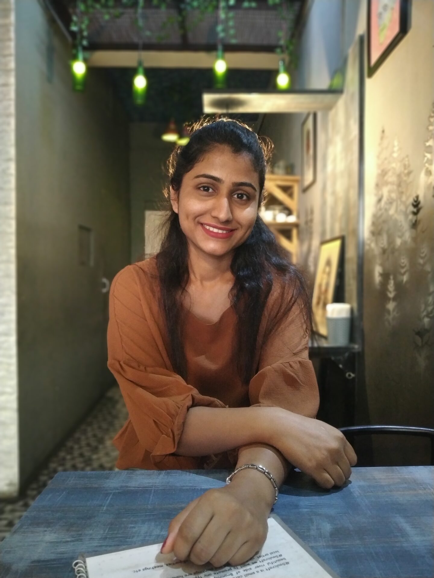 portrait-smiling-young-woman-sitting-table